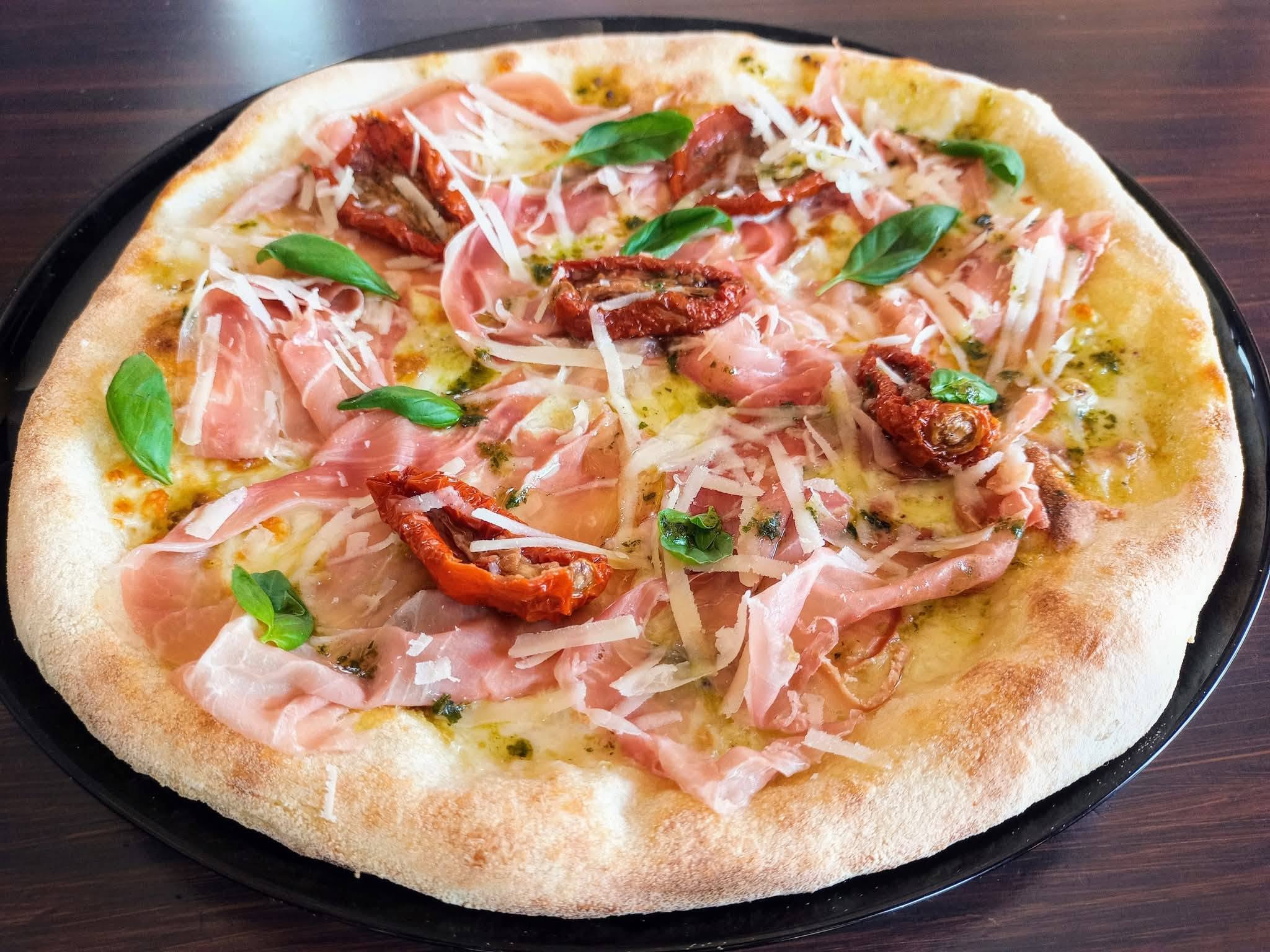 Pizza gourmet con prosciutto crudo, datterini e grana