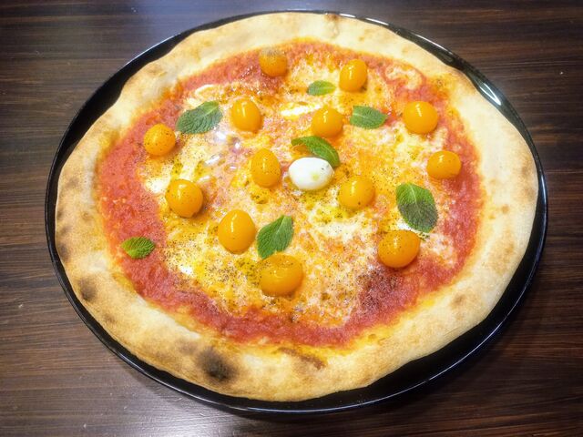 Pizza gourmet con datterini gialli pronta per la consegna